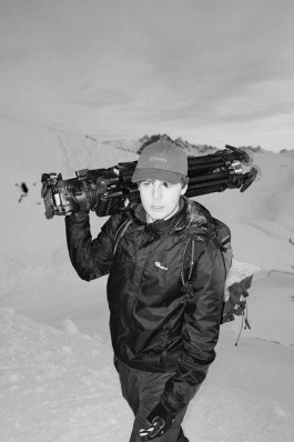 Julius Oppermann on top of an Mountain, carrying a tripot.